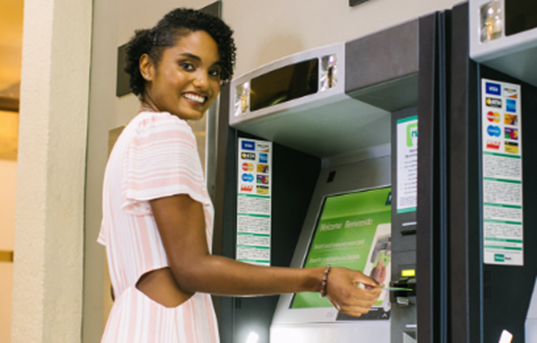 Woman taking out cash from a local ATM