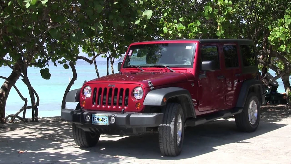 A red jeep parked on the side of a road